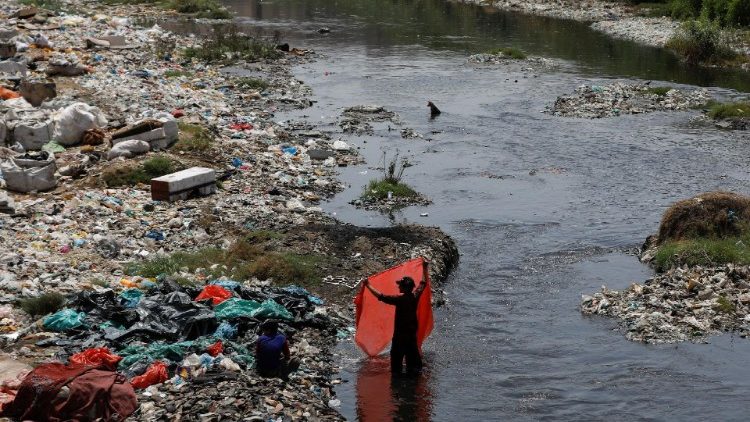 FILE: A man washes waste plastic sheets, collected for recycling, on World Environment Day in Karachi. REUTERS/Akhtar Soomro
