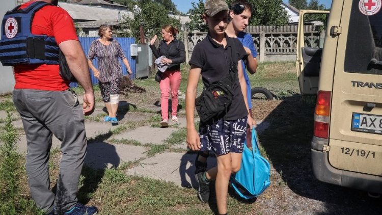 Residentes locais evacuam enquanto um voluntário da Cruz Vermelha os ajuda, em meio ao ataque da Rússia à Ucrânia, na cidade de Kupiansk-Vuzlovyi, na região de Kharkiv, Ucrânia, 15 de agosto de 2023. REUTERS/Vyacheslav Madiyevskyy