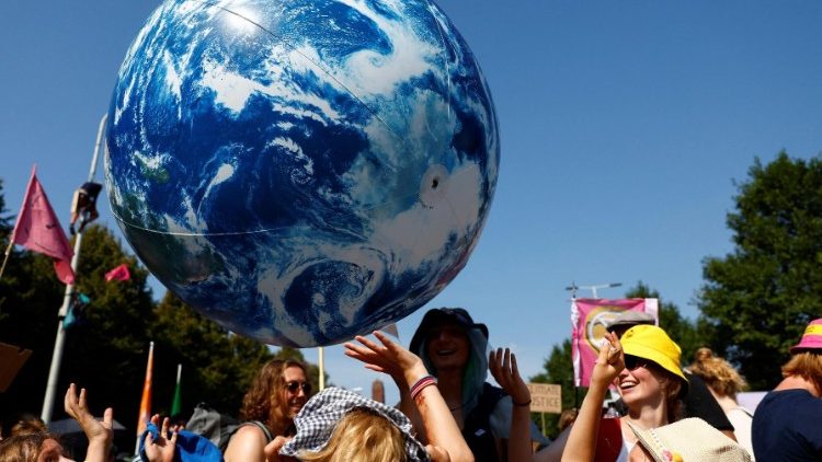 Climate activists juggle a giant inflatable blue planet