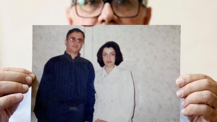 Jailed Iranian activist Narges Mohammadi's husband poses with a photo of him and his wife in Paris after she was announced winner of the 2023 Nobel Peace Prize