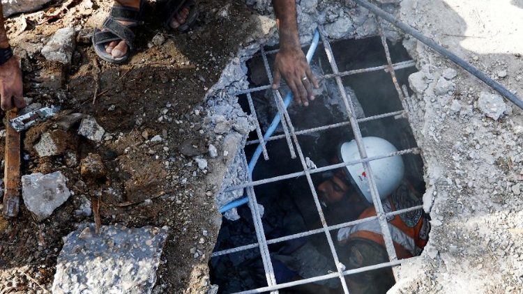 Rescue workers work at the site of an Israeli strike on a house in Khan Younis