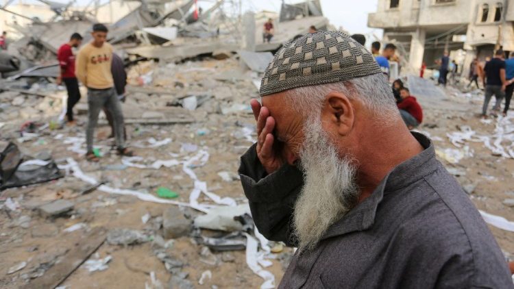 Palestinians inspect the site of an Israeli strike on a house belonging to Fojo family, in Rafah