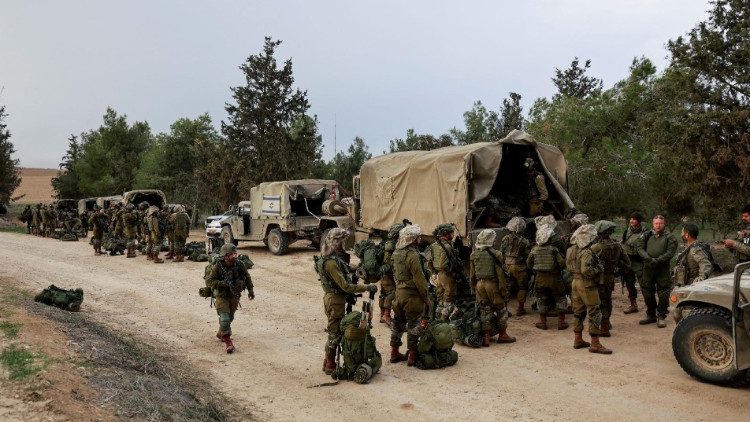 Israeli soldiers gather on the Israeli side near the border with Gaza
