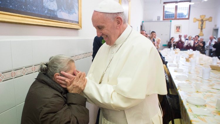 Pope Francis shares a meal with poor people at a soup kitchen  