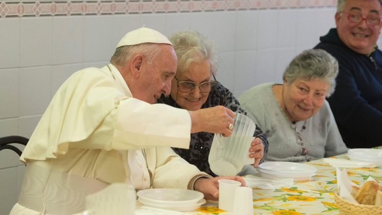 Papa Francisco servindo uma senhora durante almoço com os pobres