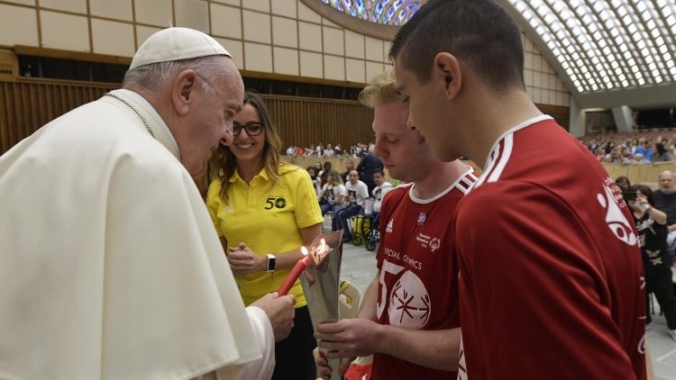 Pope Francis lights a candle from the Special Olympics torch