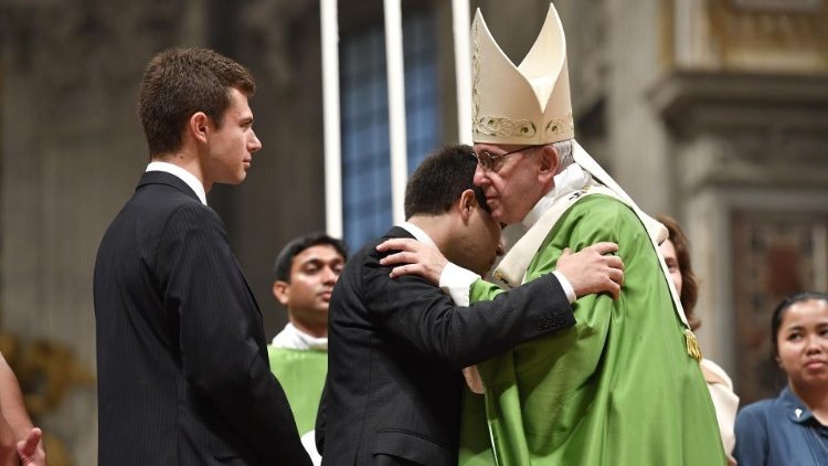 Pope greets a young auditor of the Synod of Bishops during the closing Mass