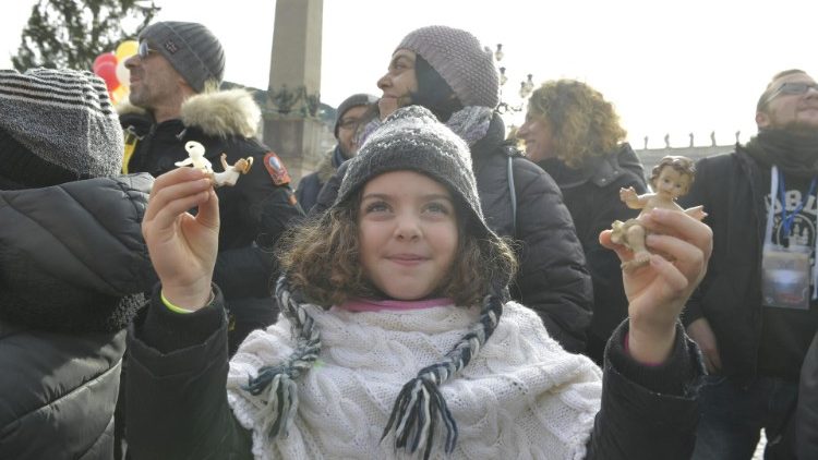 Egy kislány kezében két Kisjézus szoborral, a pápa áldására várva a Szent Péter-téren