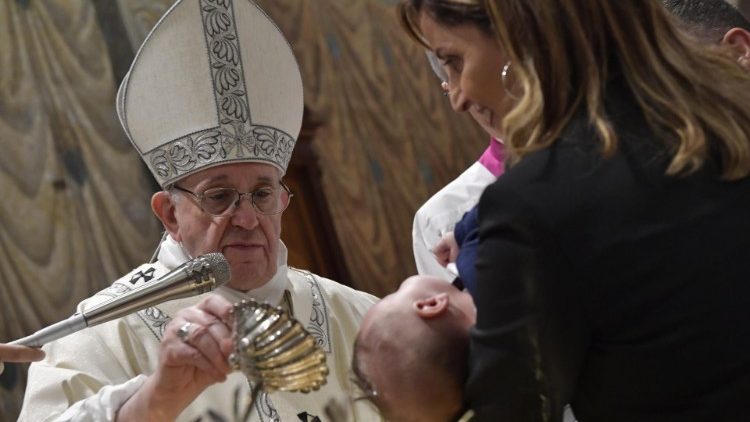 Pope Francis baptizing a child during the Mass for the Feast of the Baptism of the Lord