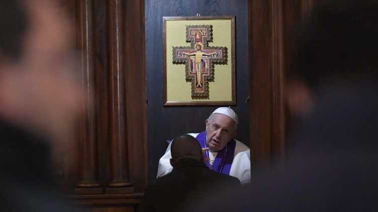 Pope Francis hears the confession of a priest before his meeting with the clergy