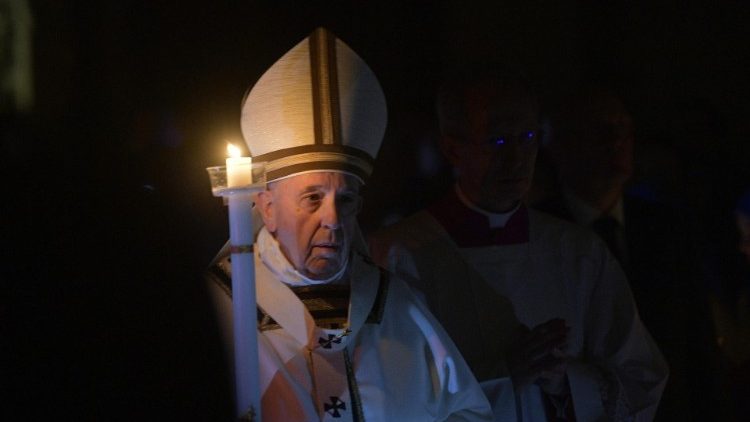 Pope Francis carries a lighted candle at the Easter Vigil