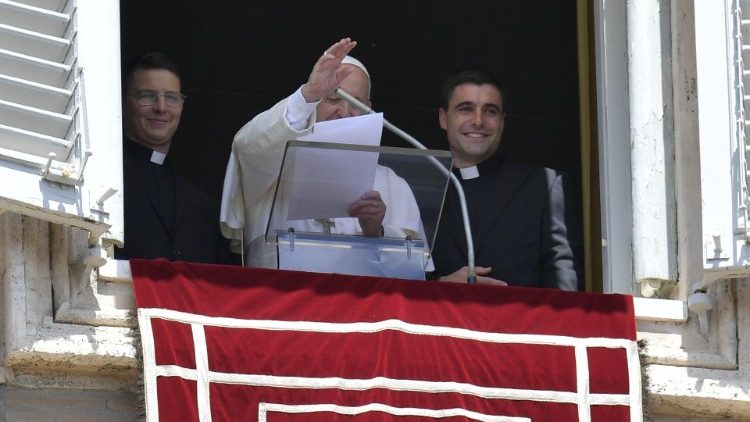 Papst Franziskus und zwei junge Priester am Fenster des Apostolischen Palastes