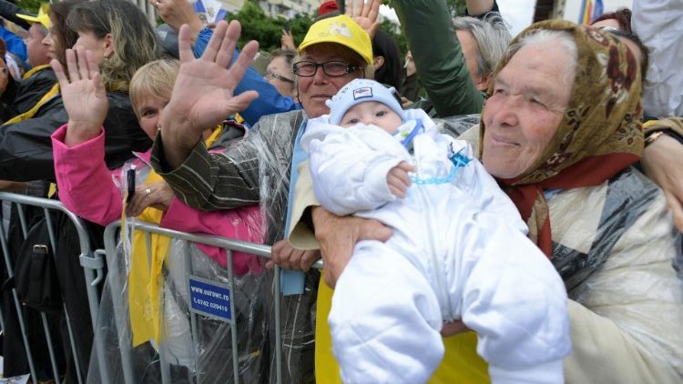 Възрастна жена показва внучето си на папата по време на визитата му в Румъния