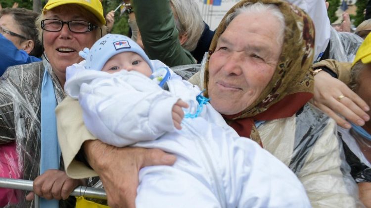 O bunică îi prezintă papei Francisc un copil în timpul călătoriei apostolice în România.