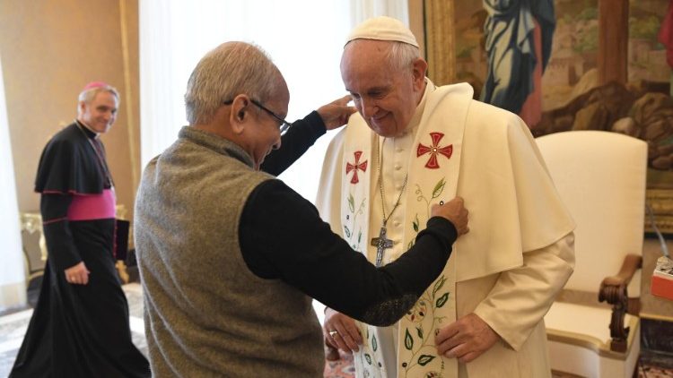 Father Cedric Prakash puts the stole on Pope Francis's shoulders during a papal audience