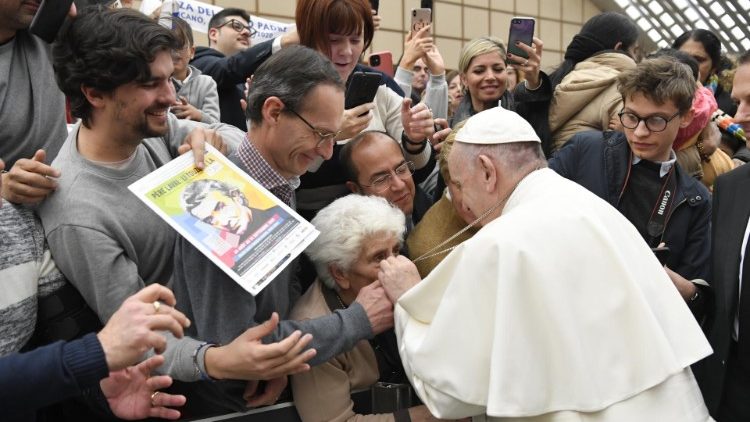 Pope Francis lets an elderly lady kiss his pectoral cross