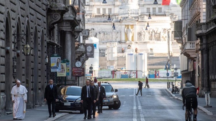 Pope Francis walks along a desolate Via del Corso
