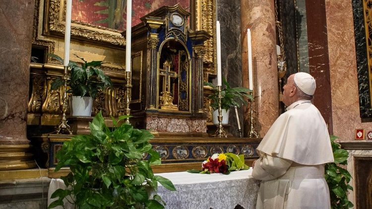 Pope Francis prays before the crucifix