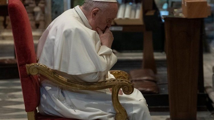 Pope Francis prays before the crucifix