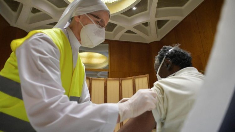 修女在梵蒂岡保祿六世大廳為貧窮人士接種疫苗