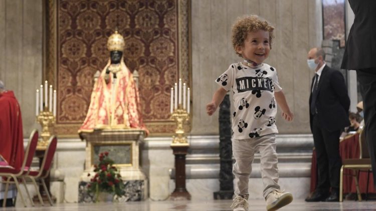 Un bambino nella Basilica vaticana durante la messa del Papa