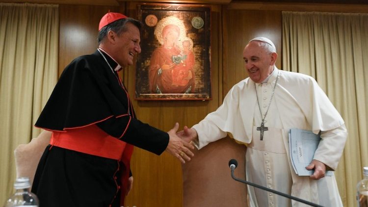 Il cardinale Mario Grech saluta Papa Francesco nell'Aula Nuova del Sinodo