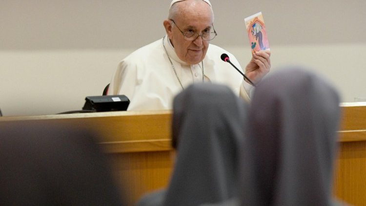 Pope Francis holds up a prayer card during his encounter with Salesian Sisters