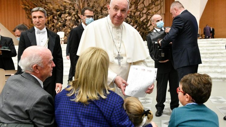 A boy presents a drawing to the Pope