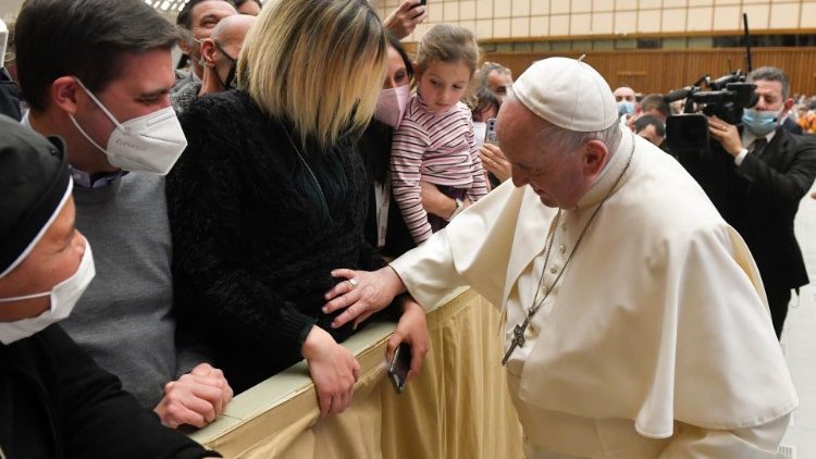 Papa Francesco tra i fedeli dell'udienza generale, benedice il piccolo che una mamma porta in grembo