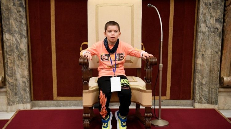 Menino autista sentado na cadeira do Papa Francisco