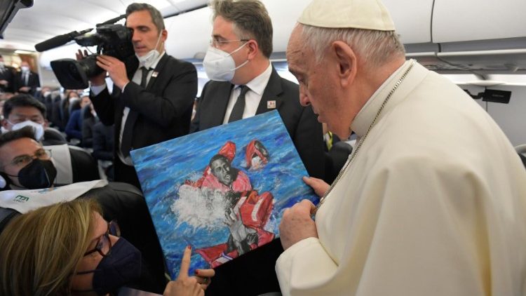 Pope Francis receives the painting by African migrant Daniel on the aircraft leading to Malta