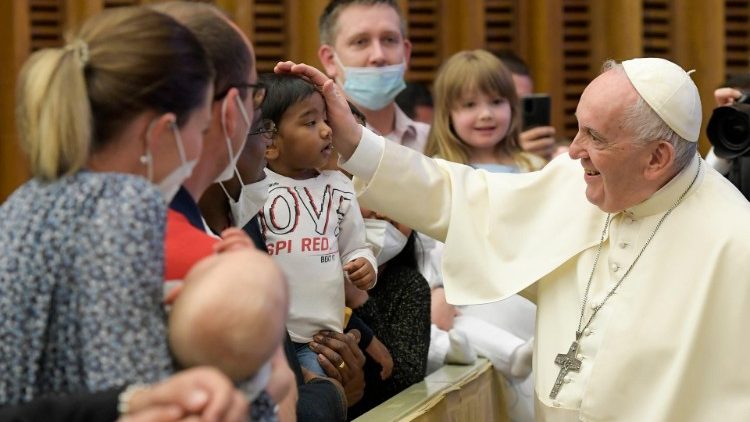 Ferenc pápa megsimogat egy kisgyermeket