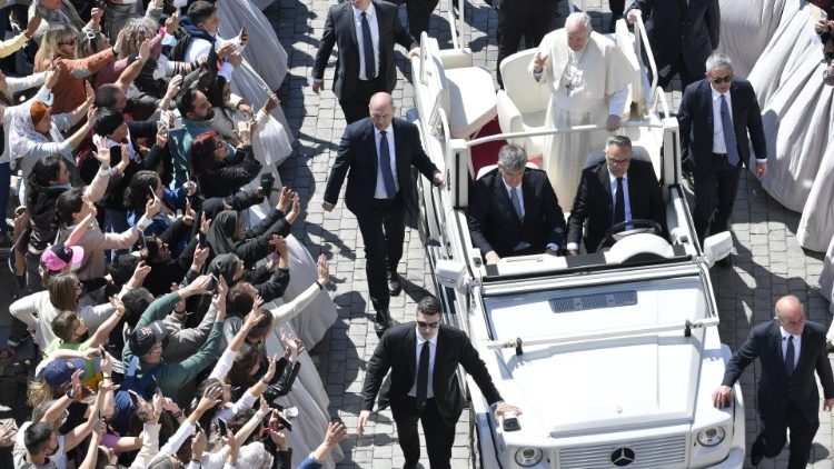 Pope Francis greets the faithful on his Popemobile