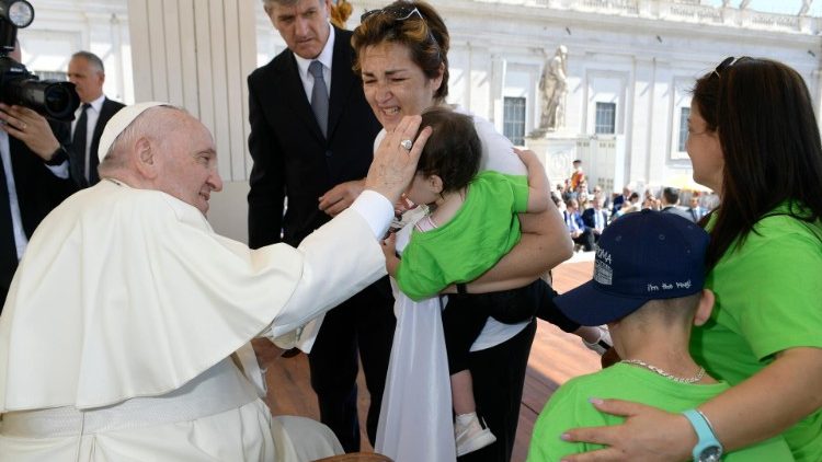 Ferenc pápa megáld egy kisgyermeket