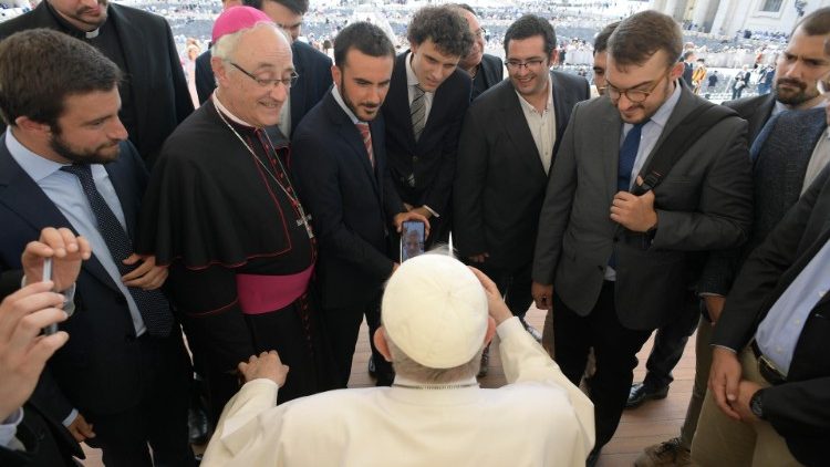 Ein sitzender Papst unterhält sich mit den Audienzbesuchern