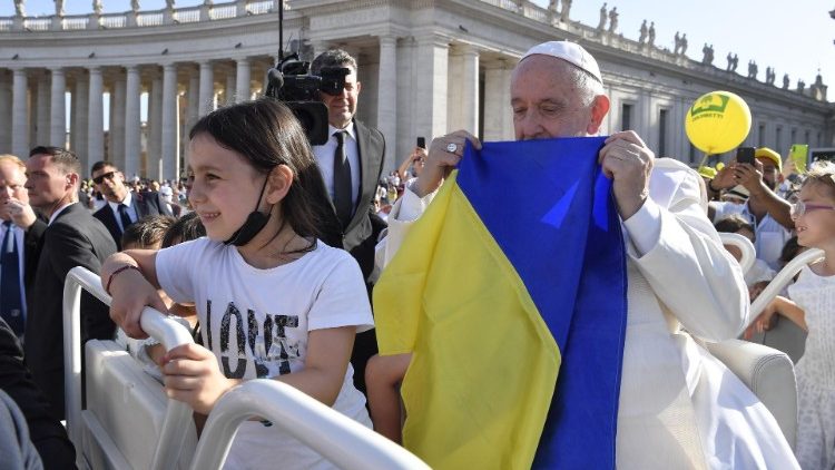 Papež líbá ukrajinskou vlajku během mše svaté pro rodiny minulou sobotu večer