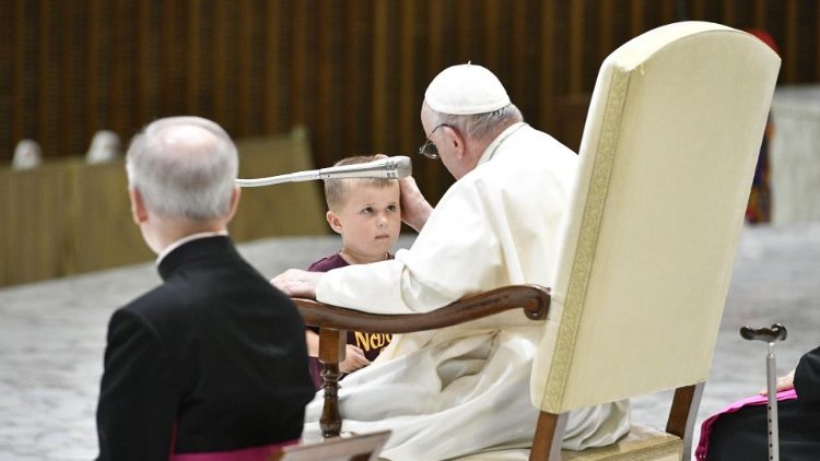 O menino que subiu ao palco da Sala Paulo VI e ficou ao lado de Francisco até o canto em latim do Pai Nosso