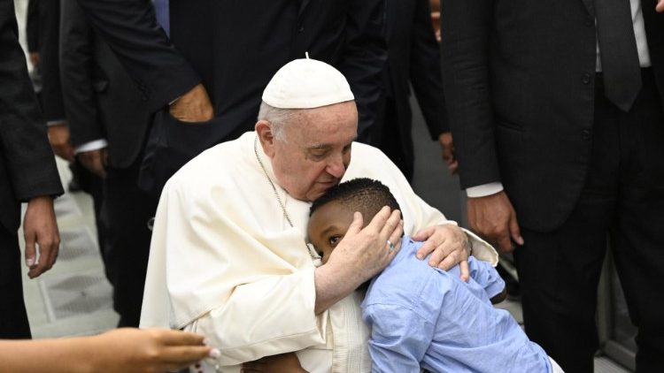 O abraço paternal do Papa ao menino, ao passar pelo corredor central da Sala Paulo VI