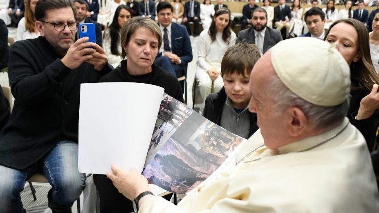 Larissa e Sergheii encontram o Papa e entregam um calendário sobre as ruínas da siderúrgica Azovstal (Vatican Media)