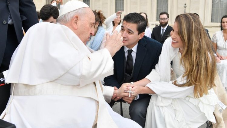 Papa Francisc salută o pereche soți recent căsătoriți care a luat parte la audiența generală din 8 martie 2023.