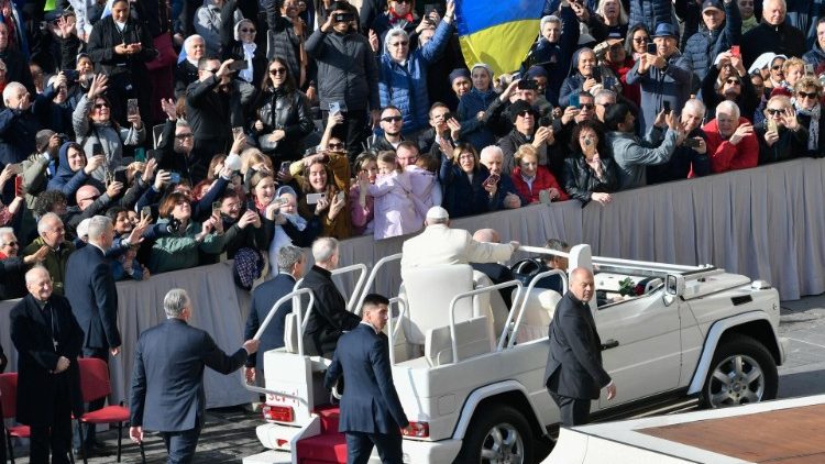 Una bandiera ucraina tenuta da alcuni fedeli in piazza San Pietro