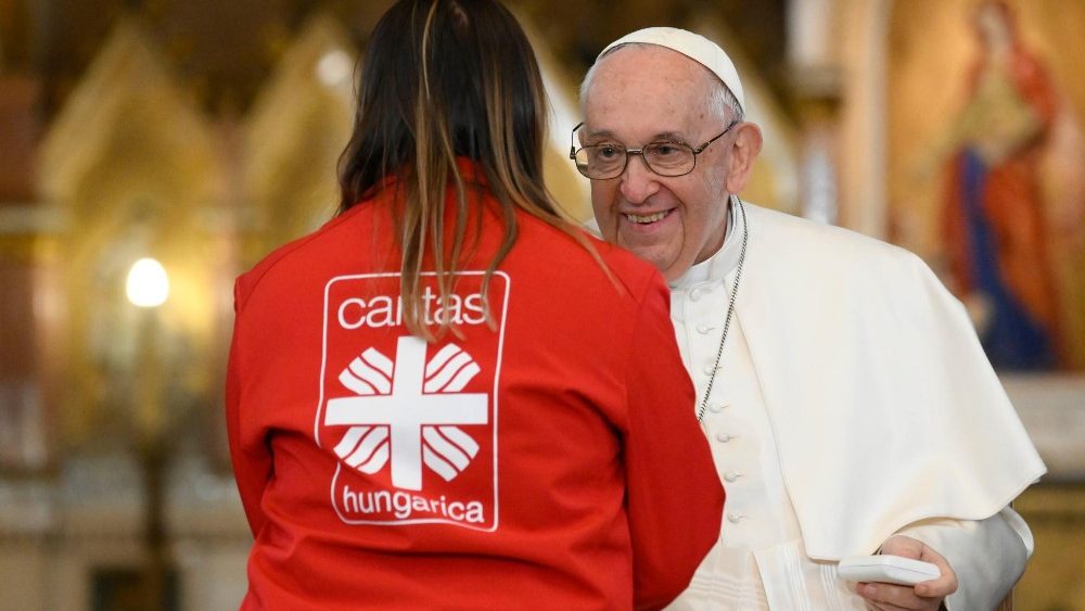 Eine junge Frau schttelt dem Papst die Hand 