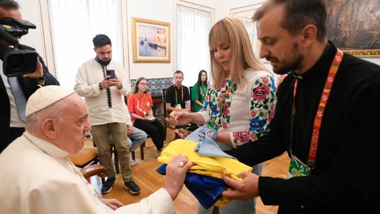 Pope Francis touches the Ukrainian flag during the audience