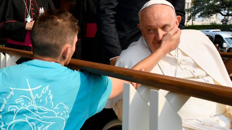 A young man caresses MAP Francis' cheek as he greets pilgrims in Fatima