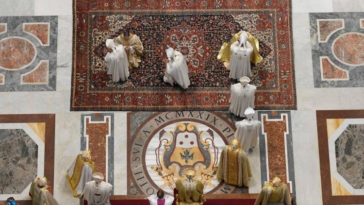 Imposición de las manos sobre los dos obispos ordenados en la Basílica Vaticana. 