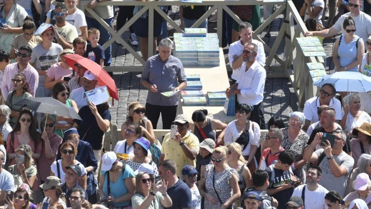 La distribuzione del sussidio per la catechesi "Passo dopo passo" ai fedeli presenti in Piazza San Pietro per l'Angelus di Papa Francesco