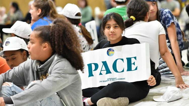 I bambini sul palco in attesa del Papa con i cartelloni "Pace"