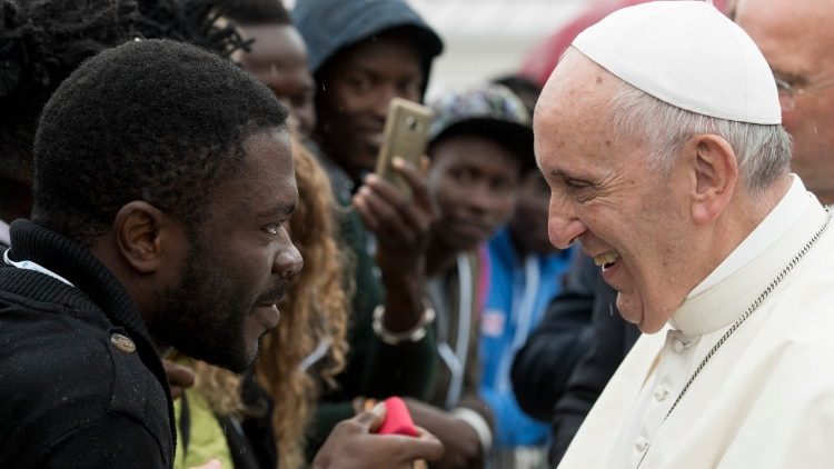 Pope Francis greets a migrant at Rome's Centro Astalli