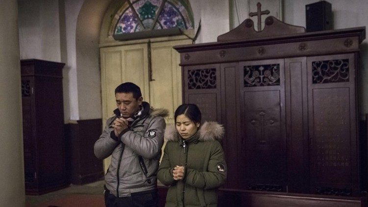 Chinese Catholics pray during Mass in Beijing
