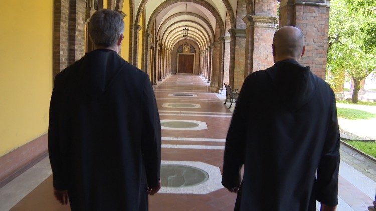 Călugări benedictini îndreptându-se către biserica abațială pentru rugăciunea comună.